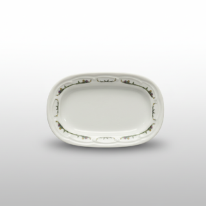 Iš viršaus nufotografuota balta stačiakampė dekoruota lėkštė 14 x 9,5 cm su gėlių ornamentais ant banguoto krašto.