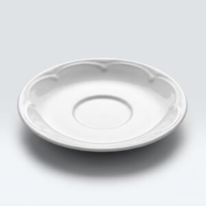 Elegantiška balta lėkštutė puodeliui 12 cm su banguotais kraštais, nufotografuota ant šviesaus stalo paviršiaus.