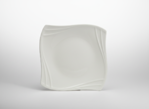 Elegantiška kvadratinė balta lėkštė 23 cm su banguotais kraštais, nufotografuota ant šviesaus neutralaus fono.