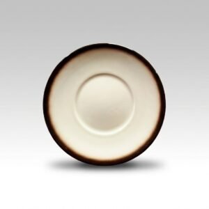 Kreminės spalvos lėkštė 17 cm su tamsiai rudu, pereinančių spalvų kraštu, nufotografuota iš viršaus ant šviesaus fono.