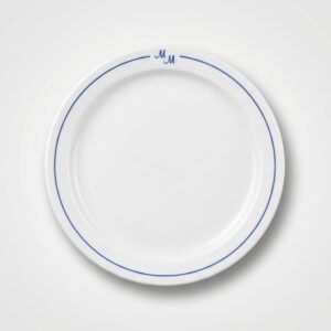 Klasikinio dizaino balta lėkštė 26 cm skersmens su plona mėlyna linija ir monograma viršuje, nufotografuota iš viršaus.