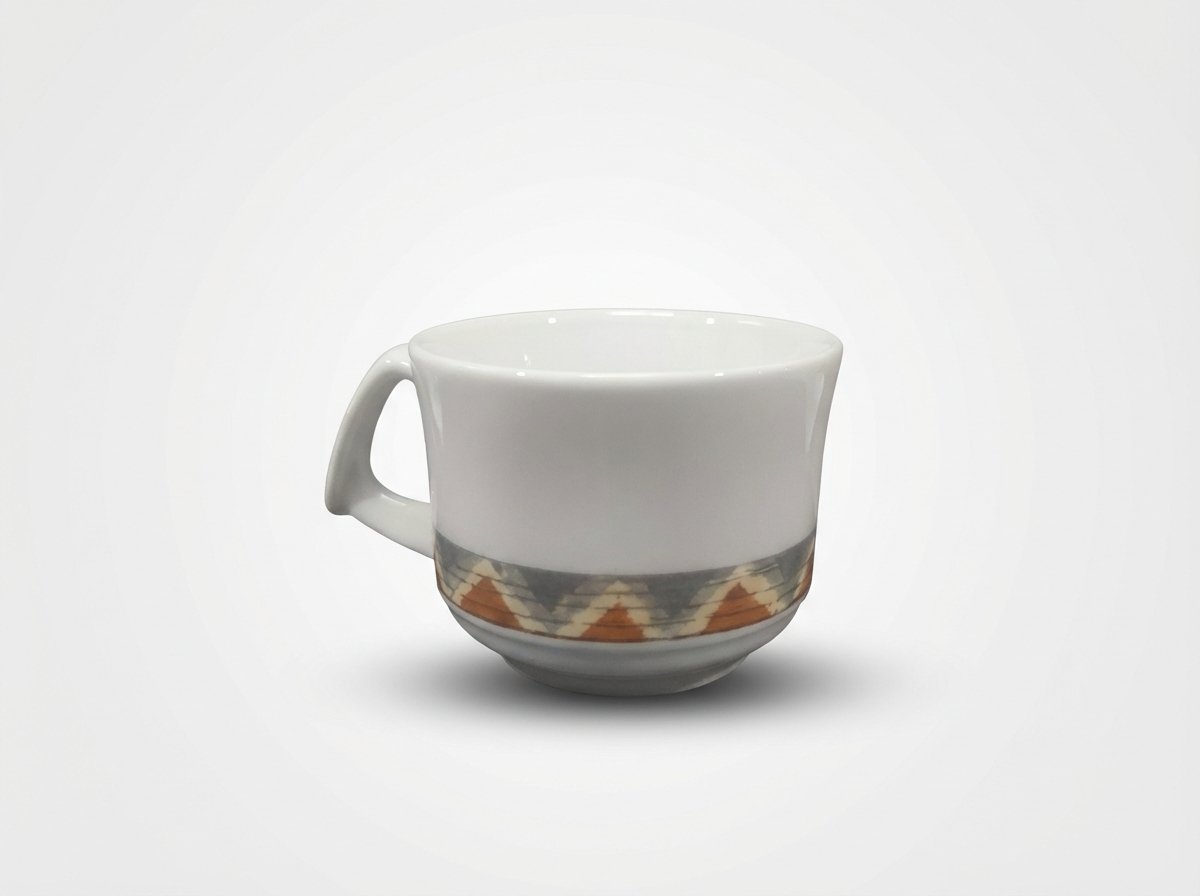 Mažas baltas puodelis 100 ml su rankenėle ir geometriniu raštu apačioje, nufotografuotas ant šviesaus fono.