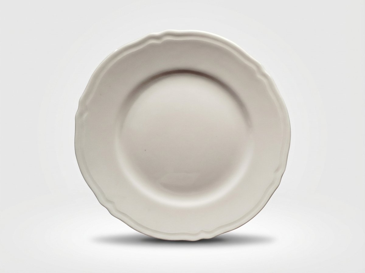 Klasikinio dizaino balta gili lėkštė 23 cm skersmens su banguotais kraštais, nufotografuota iš viršaus baltame fone.