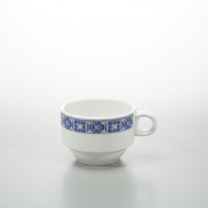 Baltas keraminis puodelis 200 ml su mėlyna ir geltona ornamentų juosta, stovintis ant šviesiai pilko pagrindo.