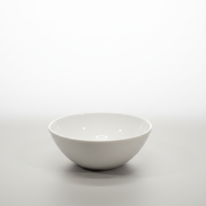 Baltas, apvalus, porcelianinis balta dubenėlis 145 ml, stovintis ant neutralaus pilko ir balto fono.