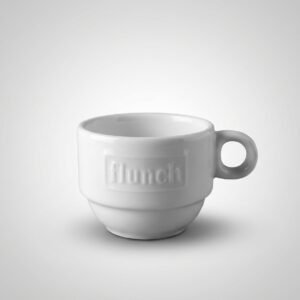 Baltas, blizgus espreso puodelis 85 ml „Lunch“ su iškiliu užrašu, nufotografuotas ant šviesiai pilko fono.