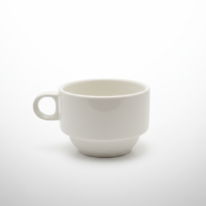 Ant balto fono stovintis baltas puodelis 190 ml talpos, pagamintas iš keramikos ir turintis patogią rankenėlę.